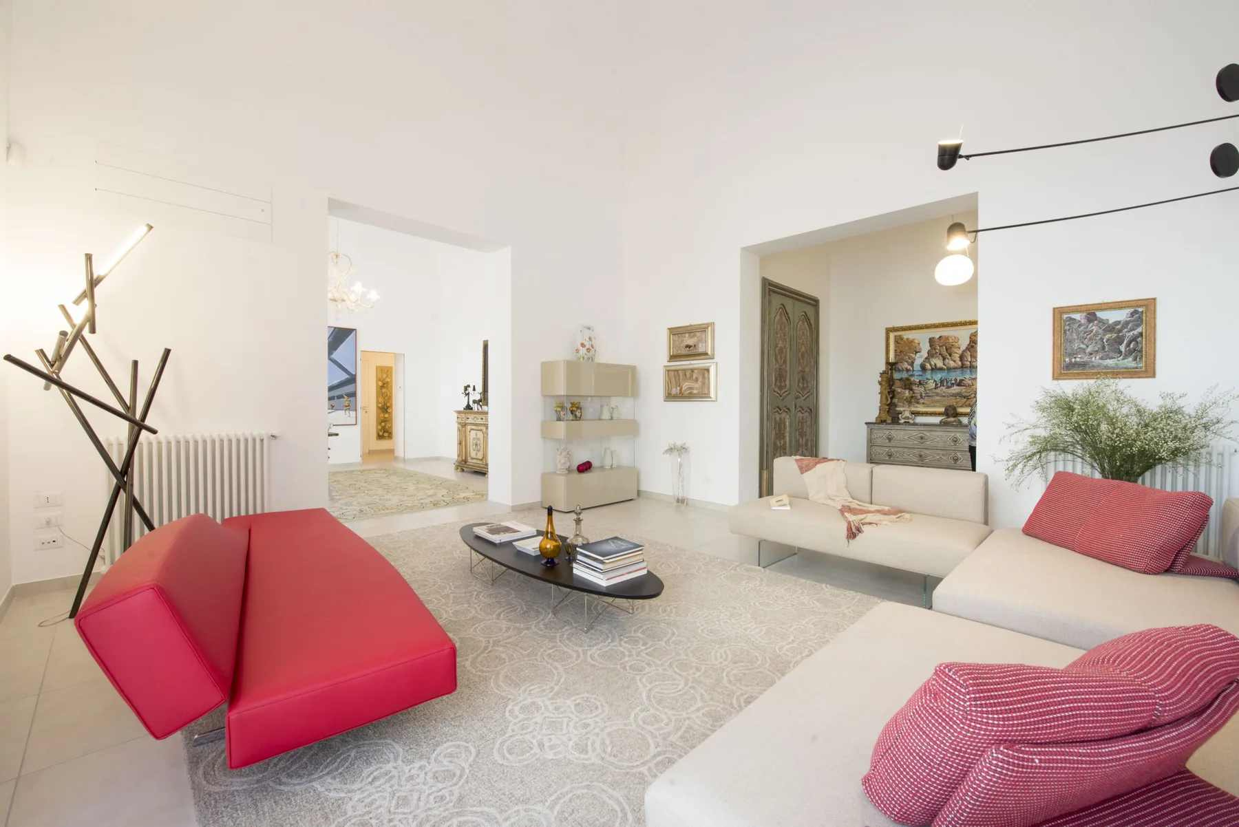 Una sala de estar luminosa con asientos rojos alrededor de una mesa de centro baja.