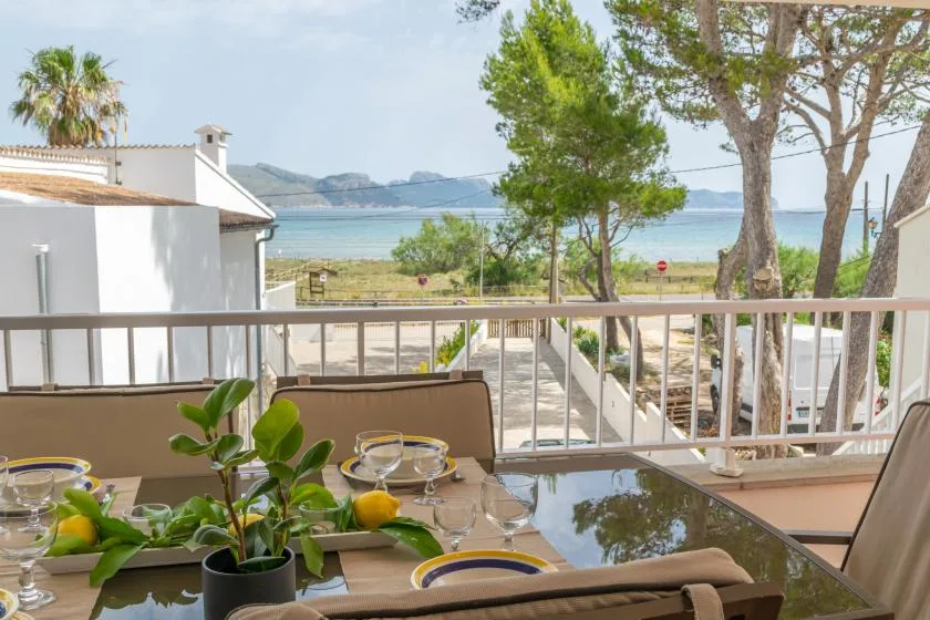Outdoor dining area with a table overlooking trees and the water.
