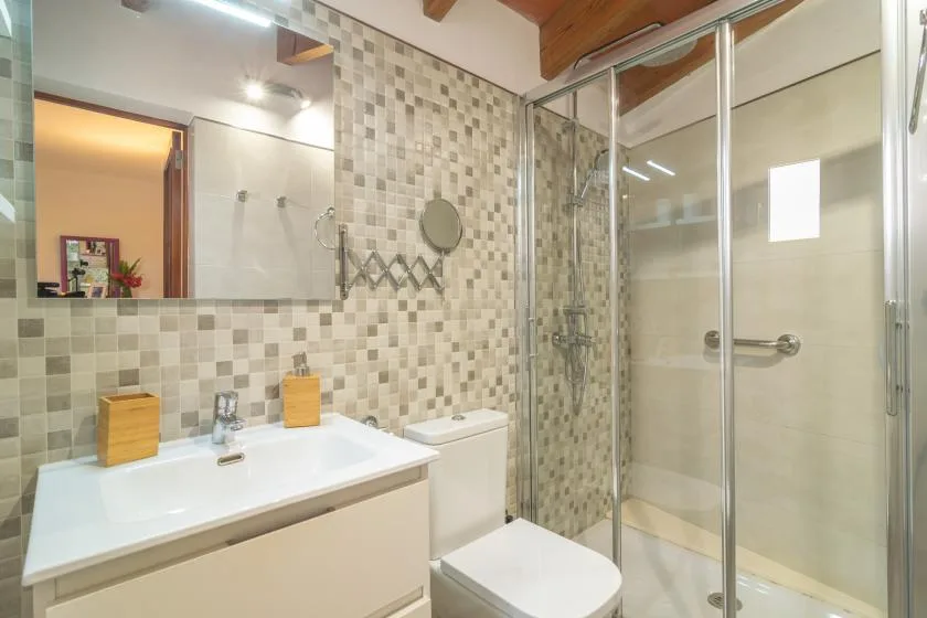 A tiled bathroom with a sink, toilet, and glass shower.