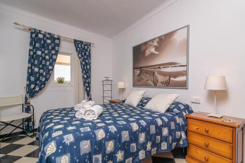 A bedroom with blue patterned bedding, white pillows, and matching curtains.