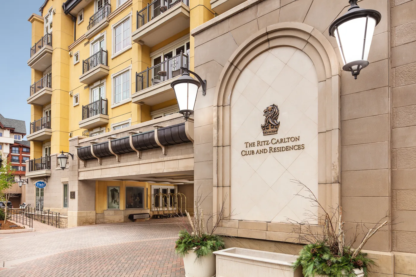 La entrada de un hotel con un arco de piedra y lámparas en la fachada.