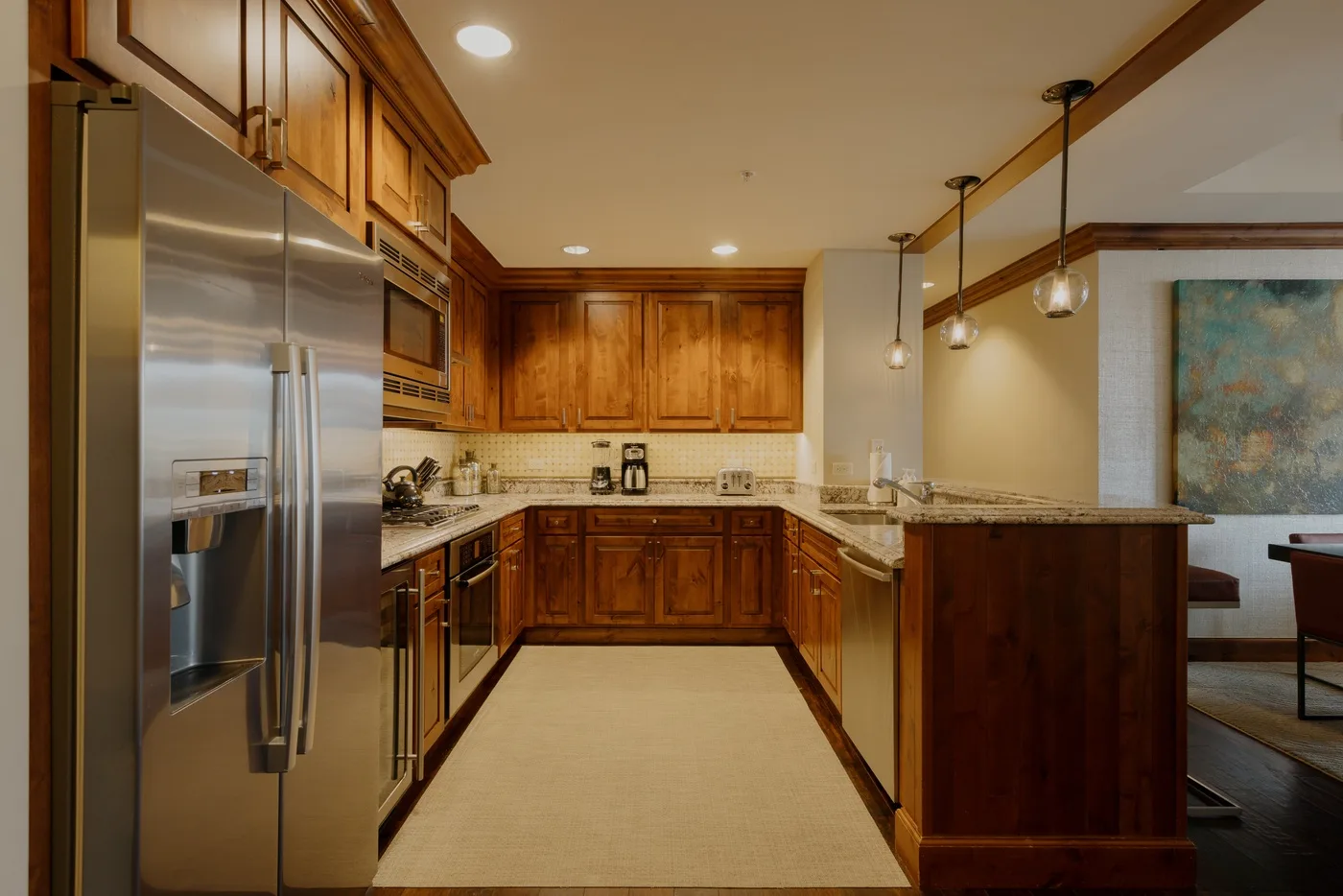 Una cocina con gabinetes de madera, electrodomésticos de acero inoxidable y una isla central.