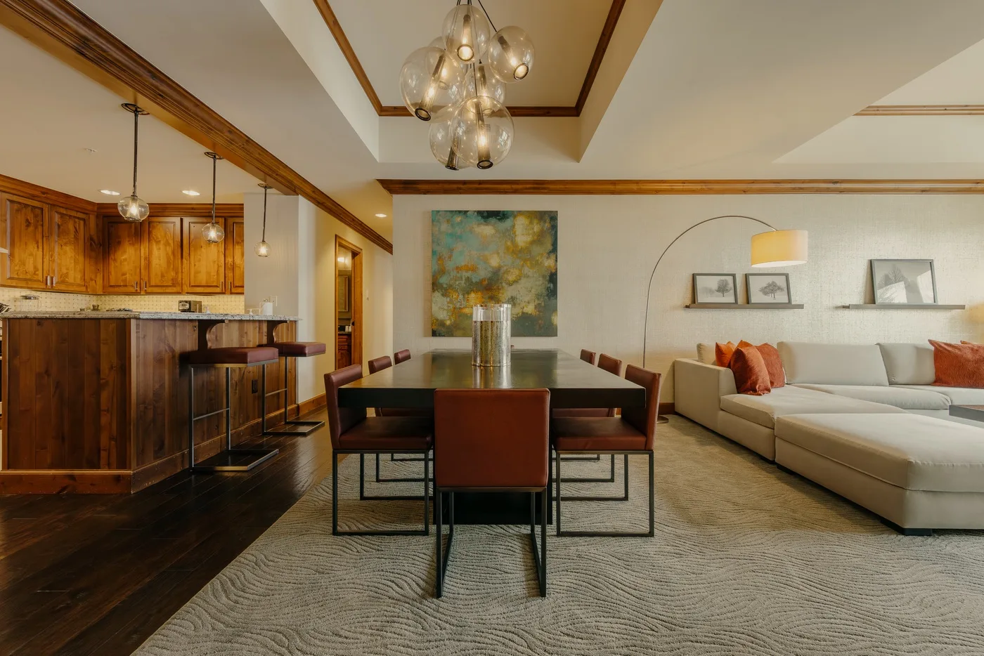 Zona de comedor y sala con una mesa, asientos y una barra de cocina.