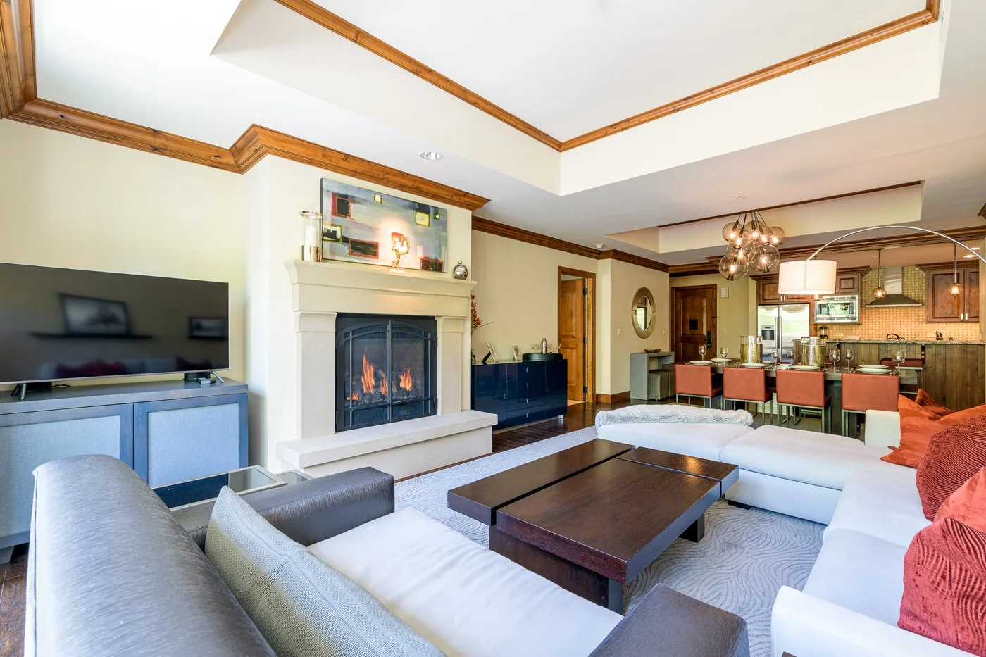 Una sala de estar con chimenea, asientos y una cocina abierta.