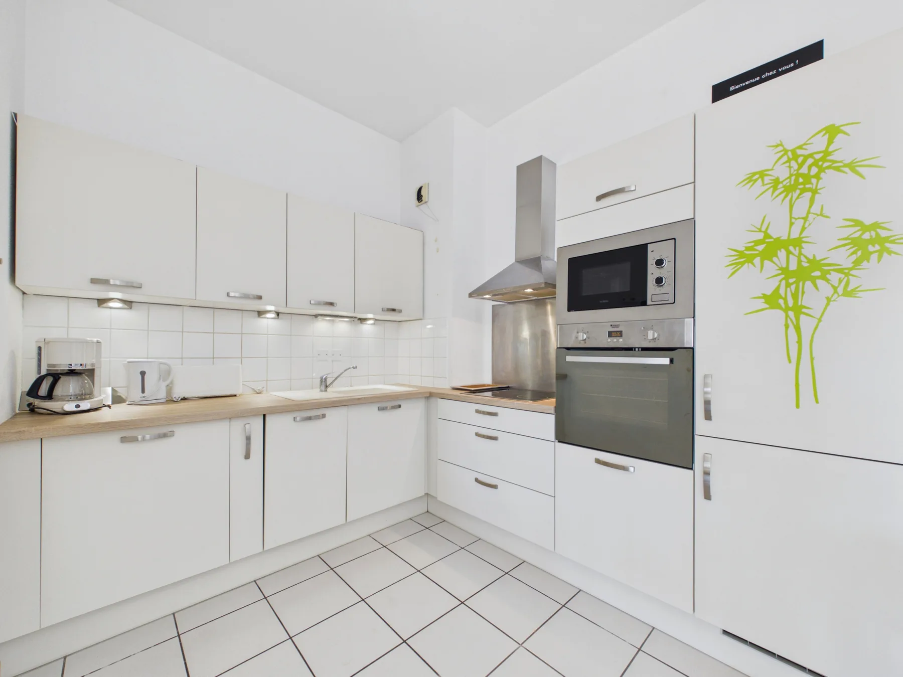 A bright white kitchen with a countertop and built-in appliances.