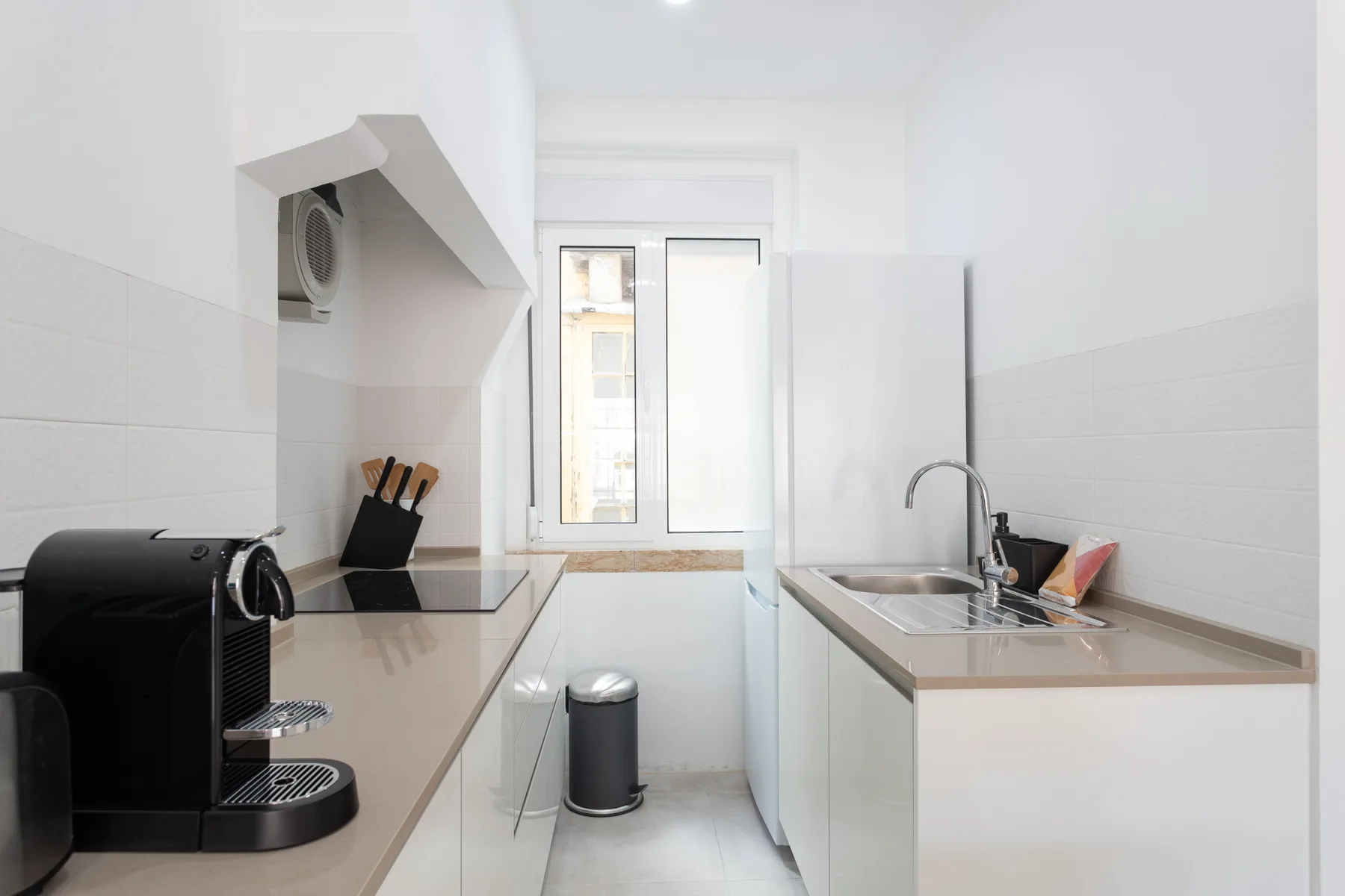 A bright kitchen with counters on both sides and a window at the far end.