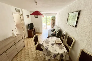 A dining area with a patterned table beside a small seating area.