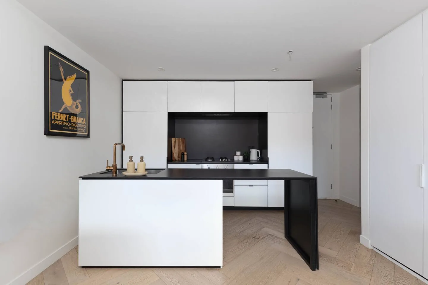 A modern kitchen with white cabinets and a central island.