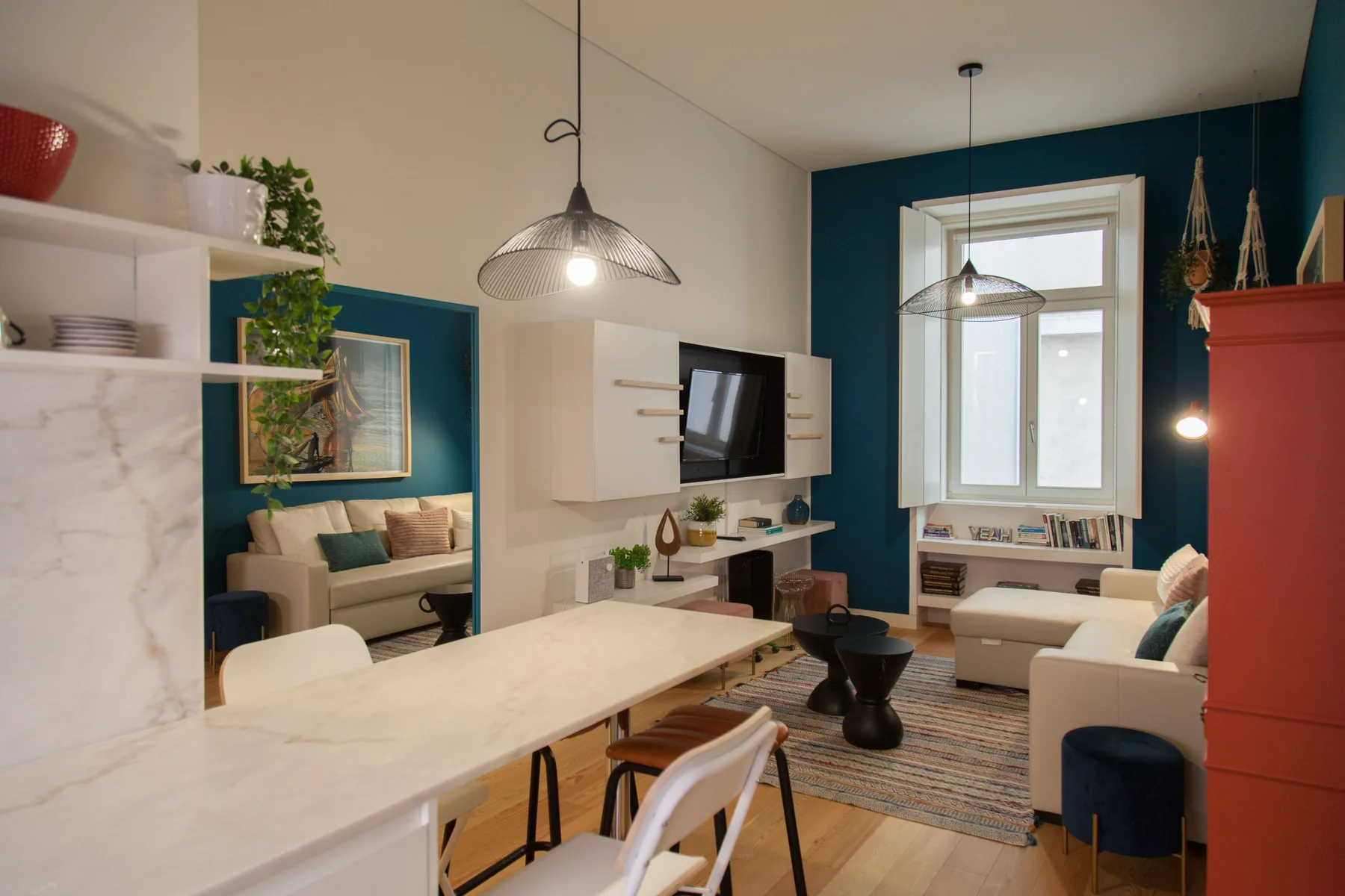 Una luminosa sala de estar y comedor cuenta con una mesa, asientos y un televisor.