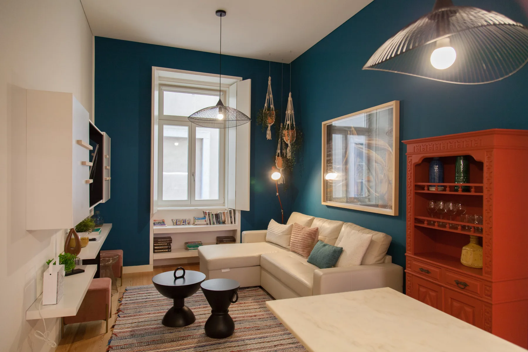 Sala de estar con asientos, una mesa de centro y una ventana grande.