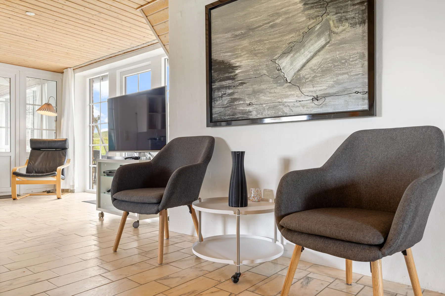A bright living room with seating arranged around a television and coffee table.