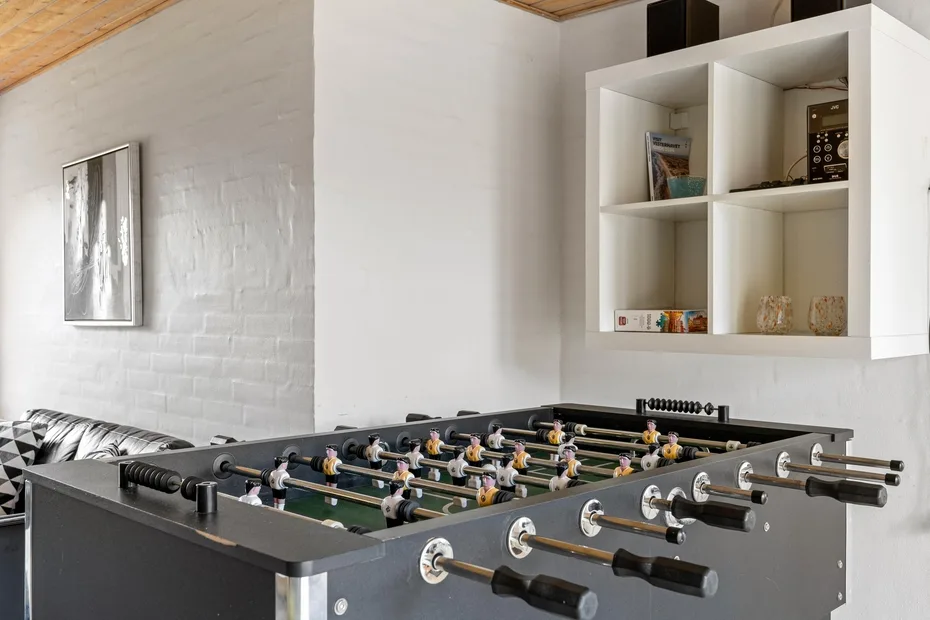 A foosball table fills a bright indoor recreation area.