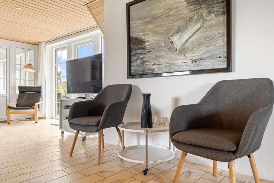 A bright living room with gray seating and large windows.