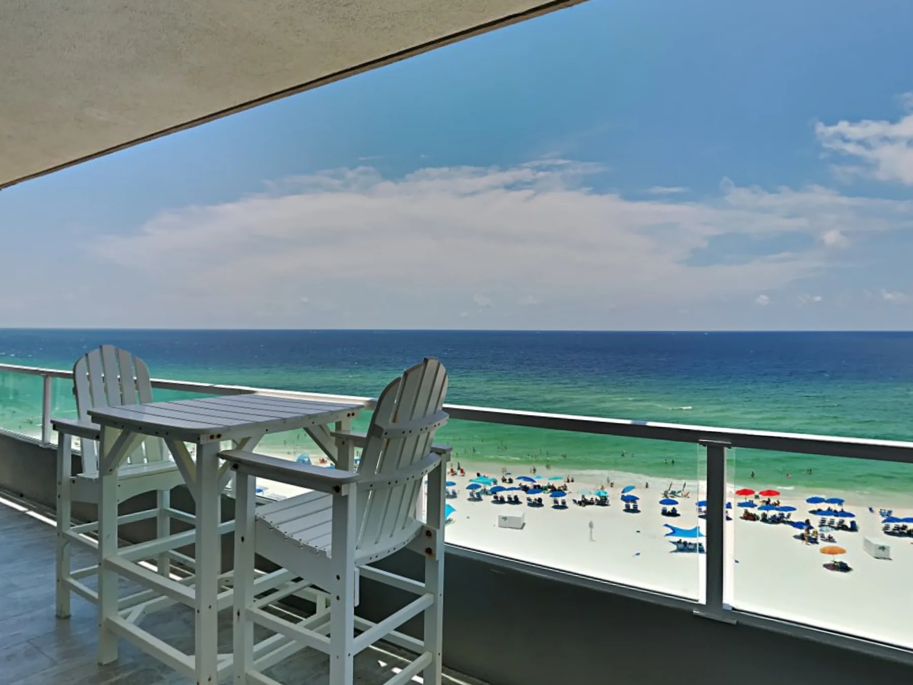 A balcony seating area overlooks the beach and ocean.