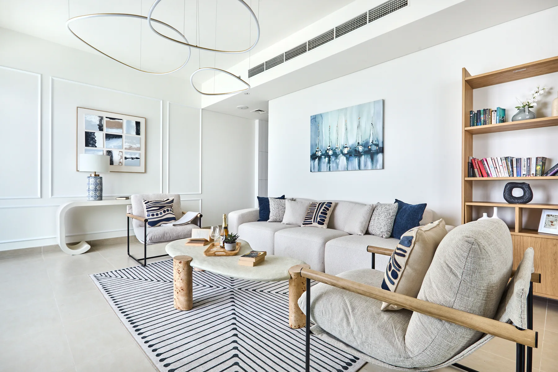A bright living room with a light-colored sofa and a striped rug.