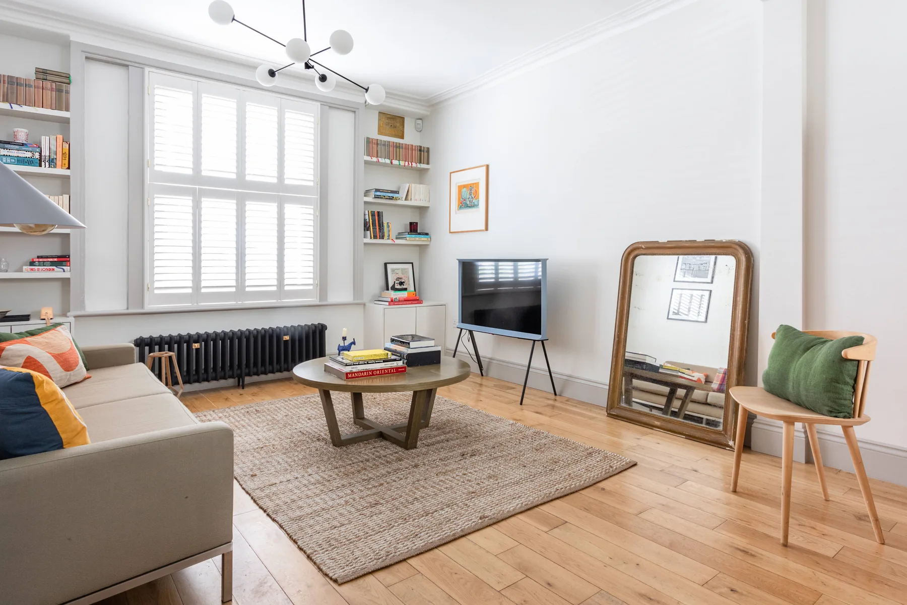 A bright living room with a seating area, coffee table, and television.