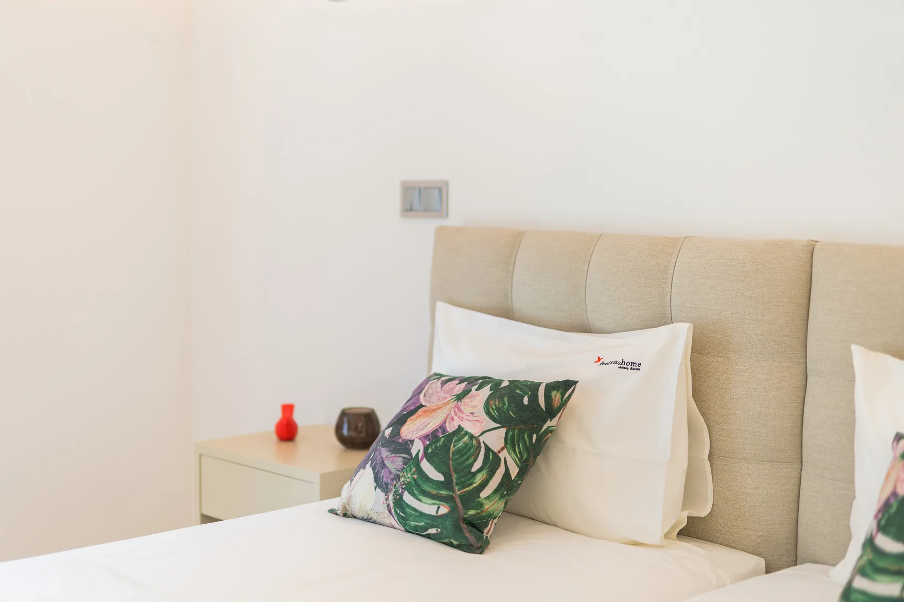 A bedroom with a bed and colorful patterned pillows.