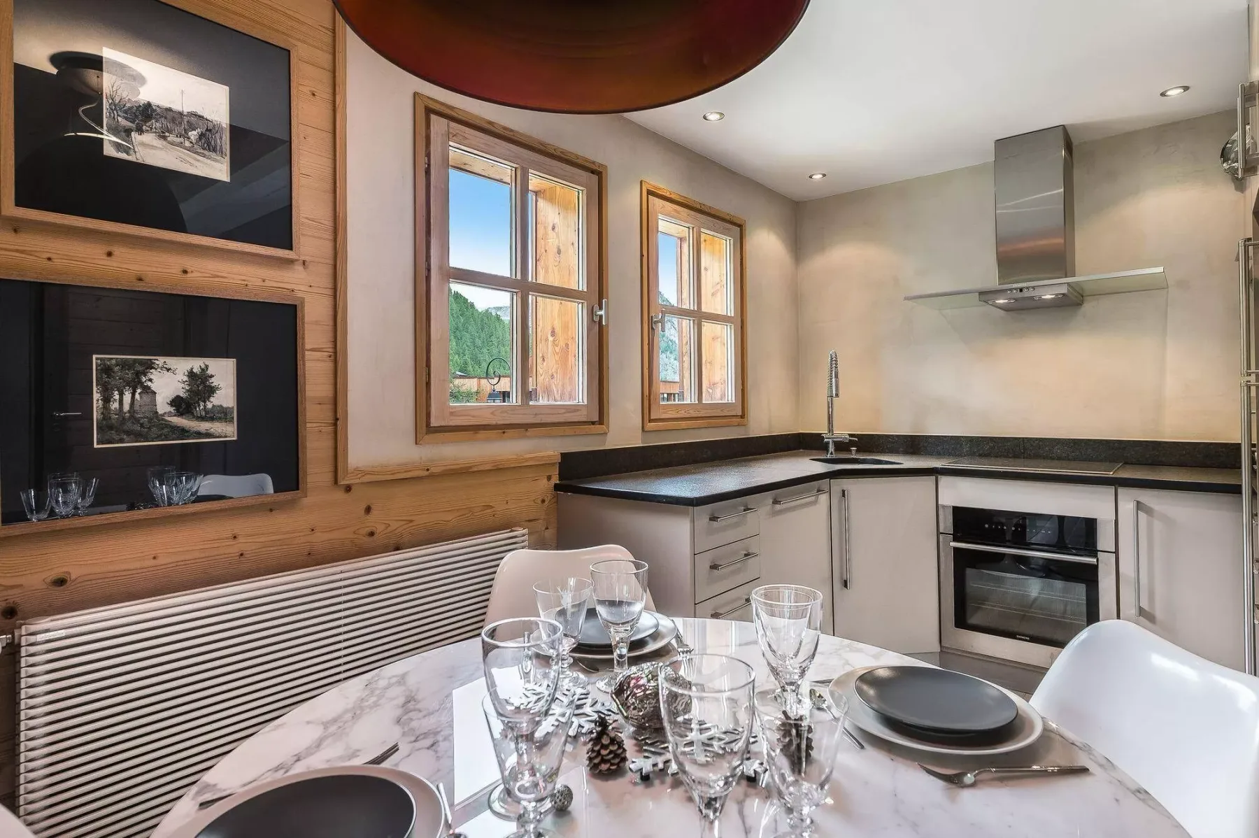 A kitchen and dining area with a countertop, oven, and table set for a meal.