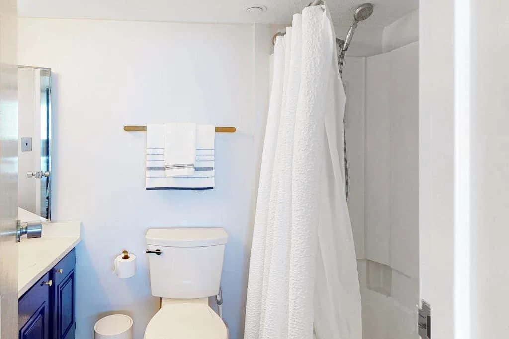 A bathroom with a toilet, sink, and shower.