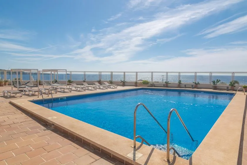 An outdoor swimming pool with lounge seating beside it.