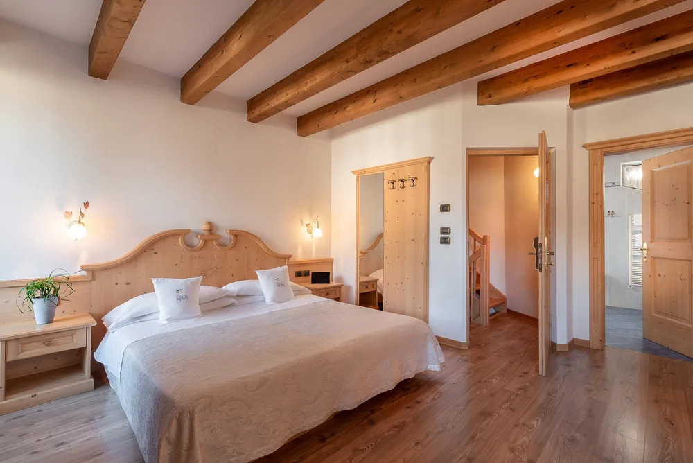 Habitación superior con cama doble y detalles de madera.