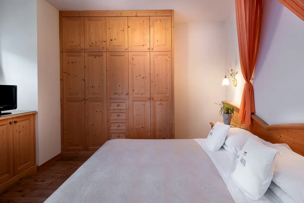 Habitación económica con muebles de madera y cama doble.