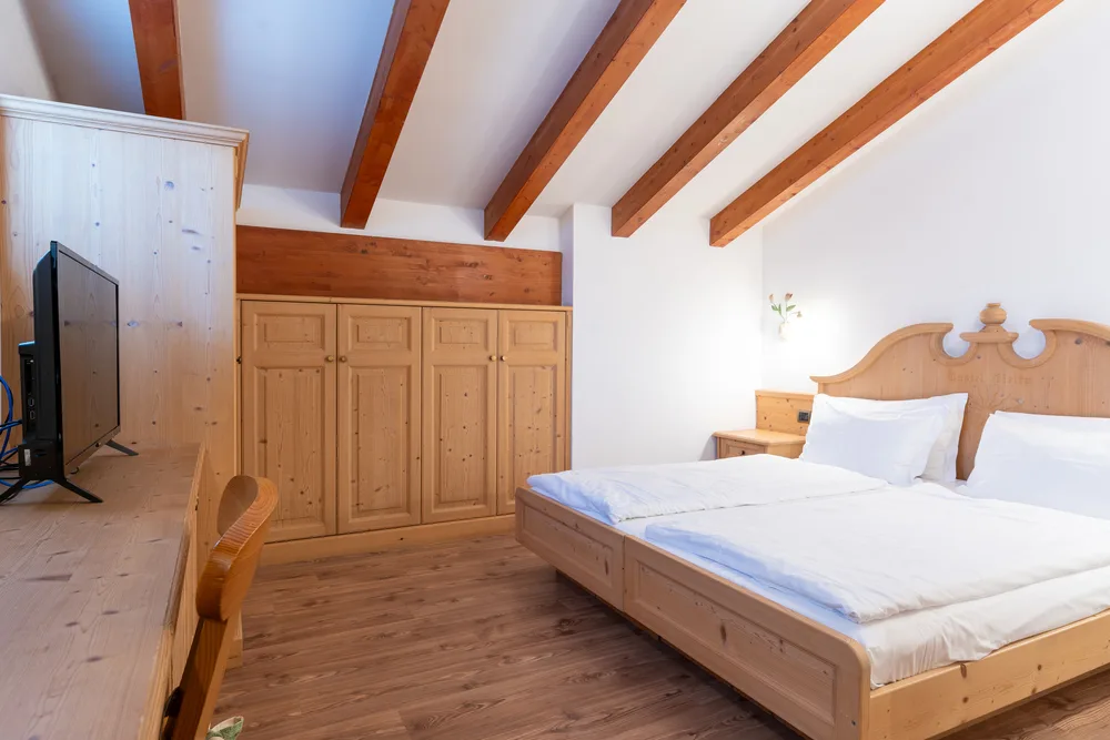 Habitación económica con cama doble y muebles de madera clara.