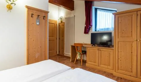 Habitación estándar con escritorio y muebles de madera.