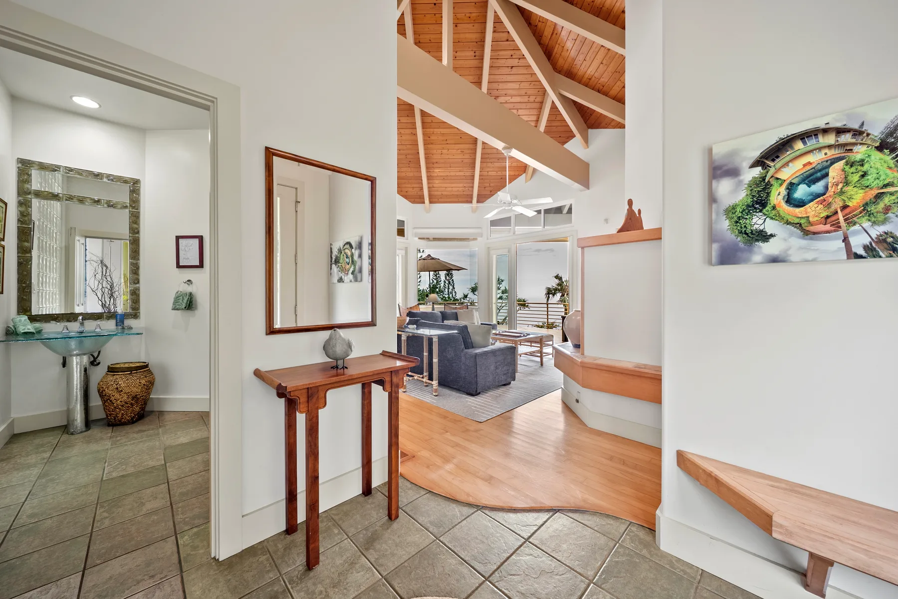 A bright open living area with a vaulted wood ceiling and seating.