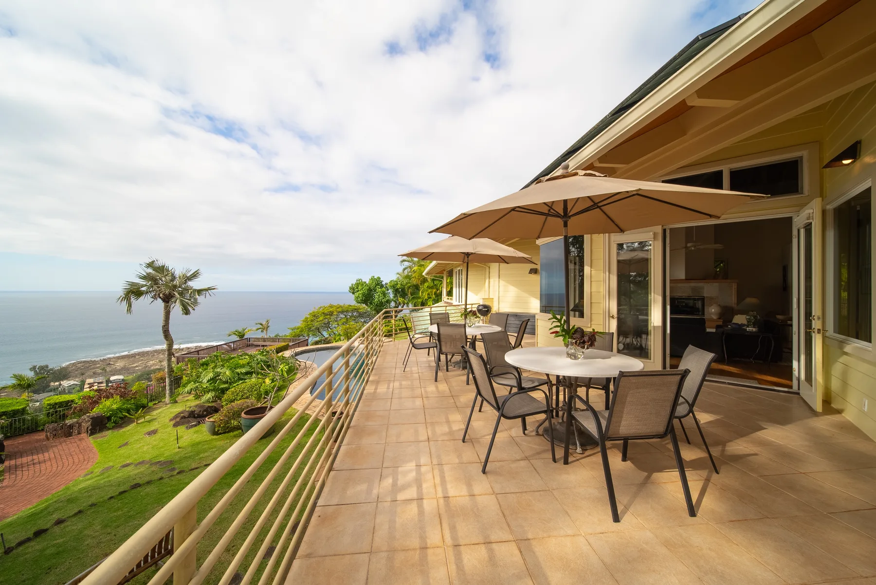 A seaside patio with outdoor seating and an ocean view.