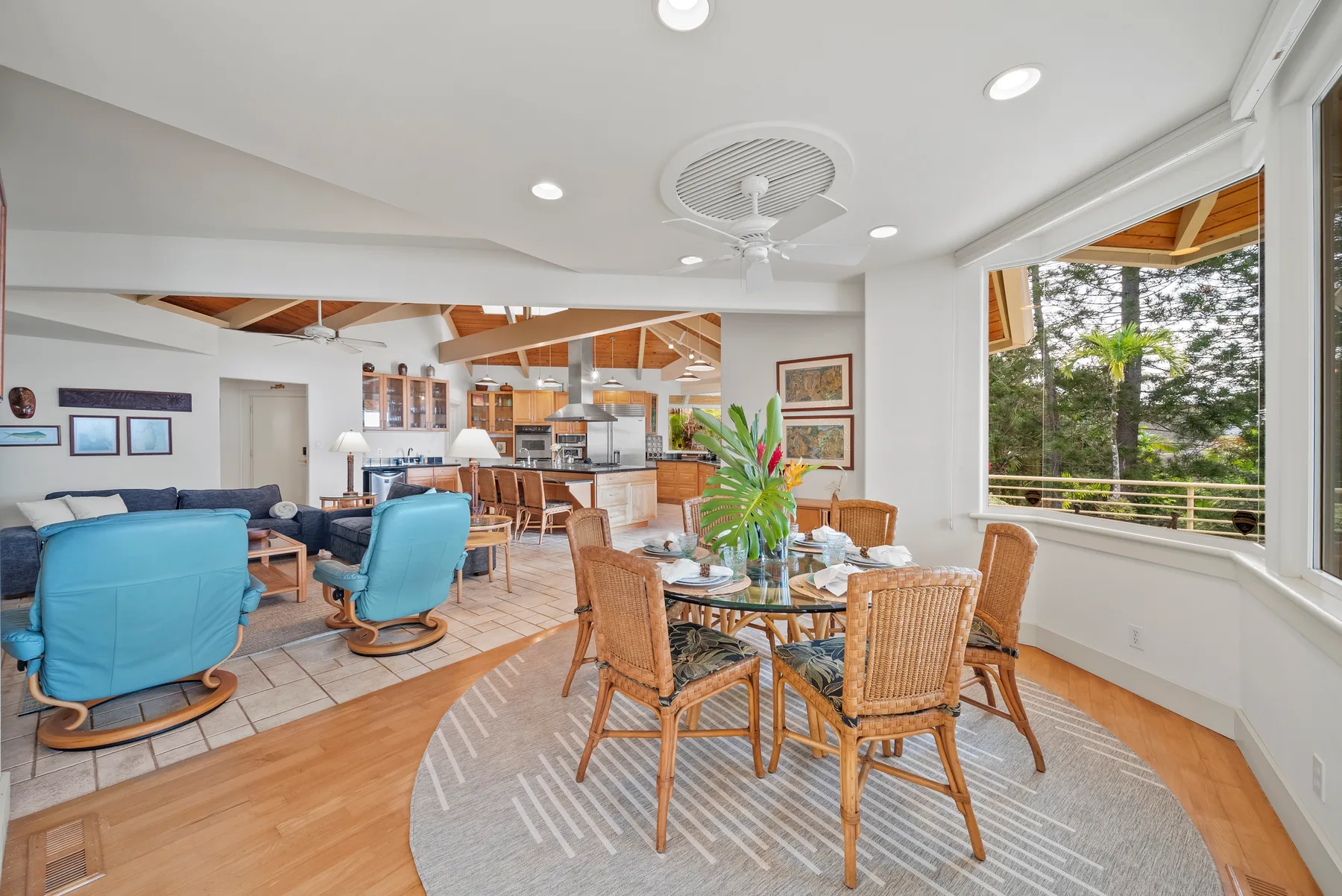 A bright living and dining area has seating, a table, and large windows.