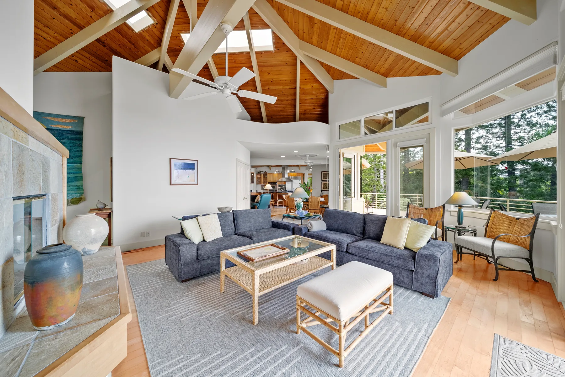 A bright living room with seating beneath a vaulted wood ceiling.