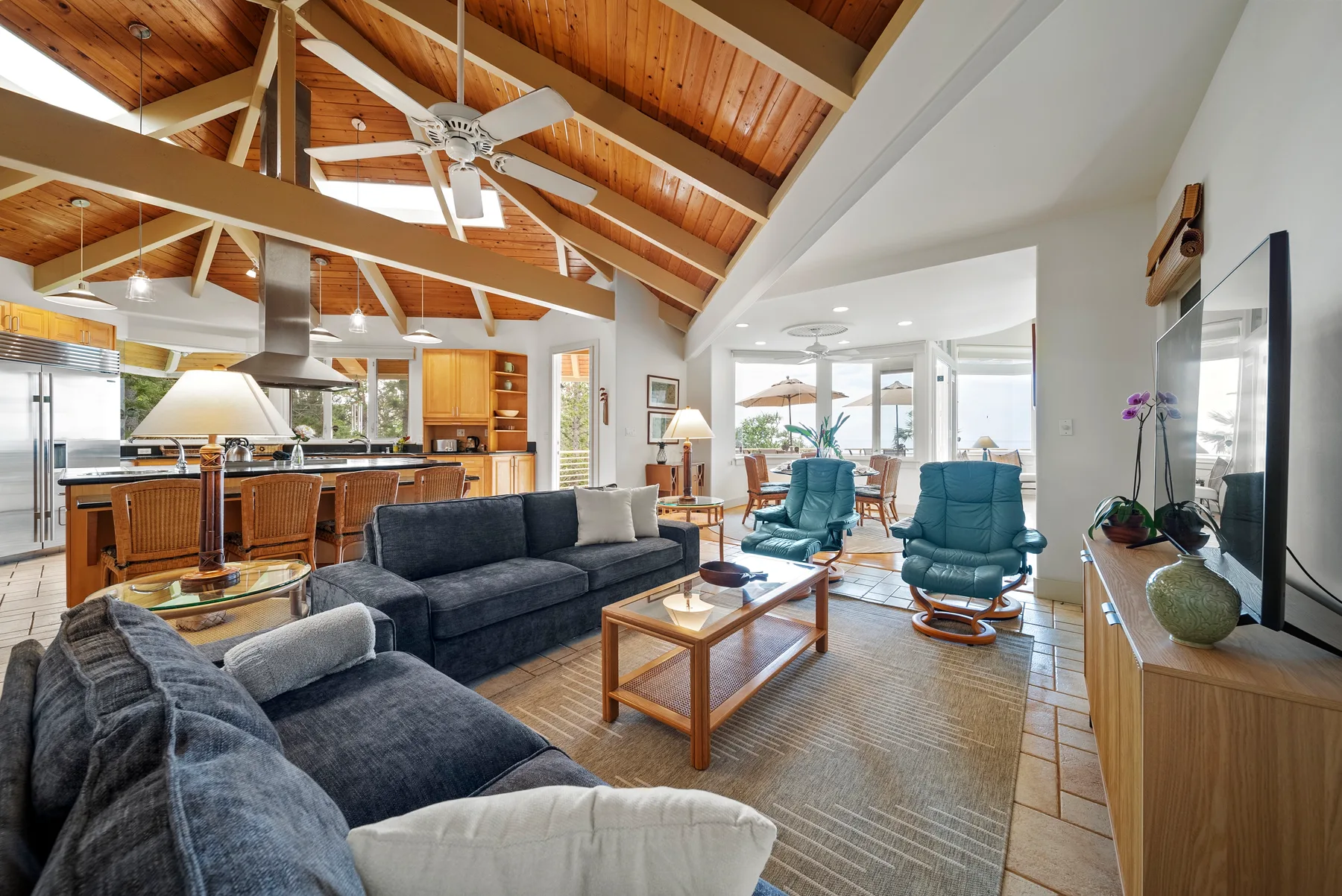 A bright living room with seating, a coffee table, and an open kitchen.