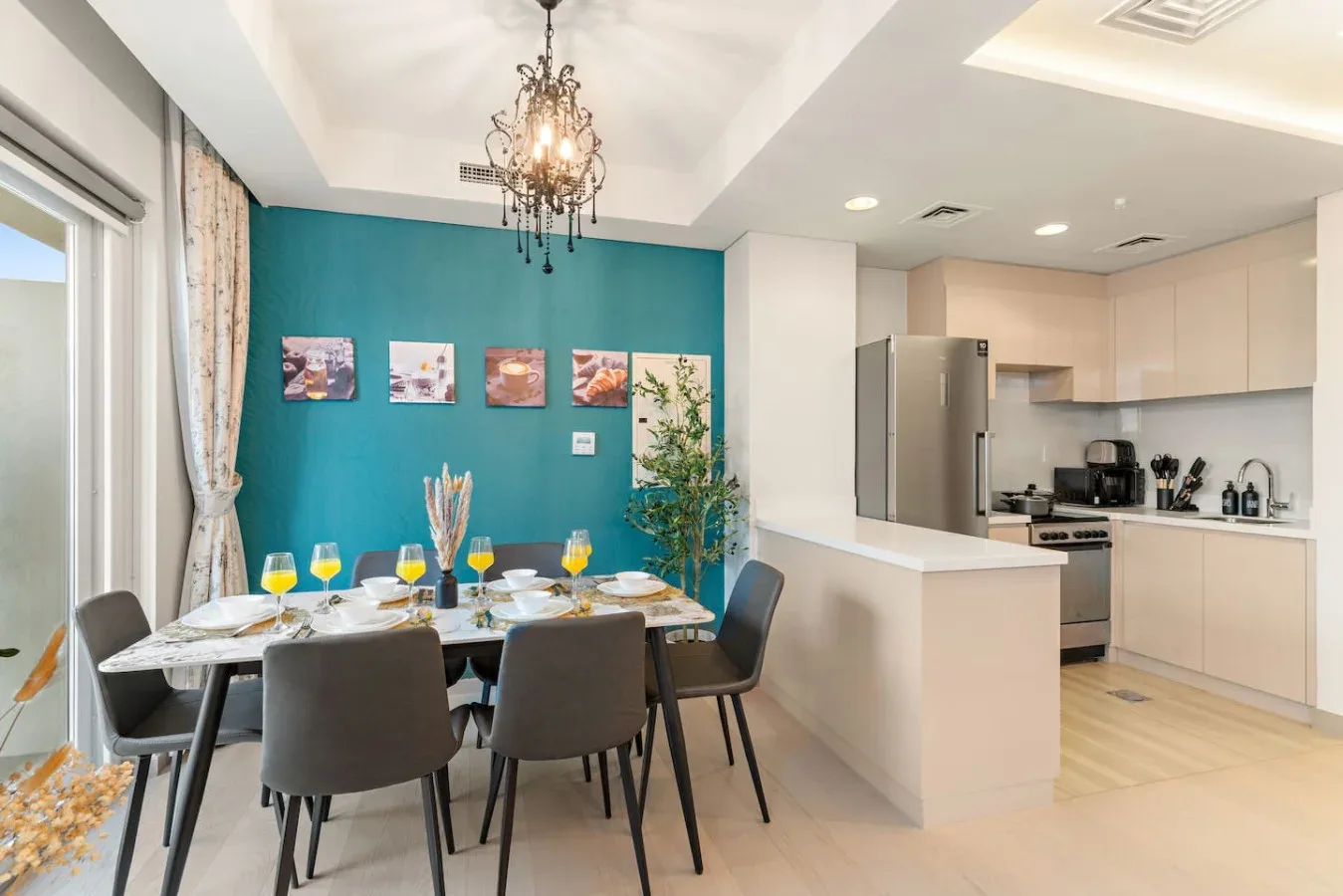 Un comedor con la mesa puesta junto a una cocina abierta.