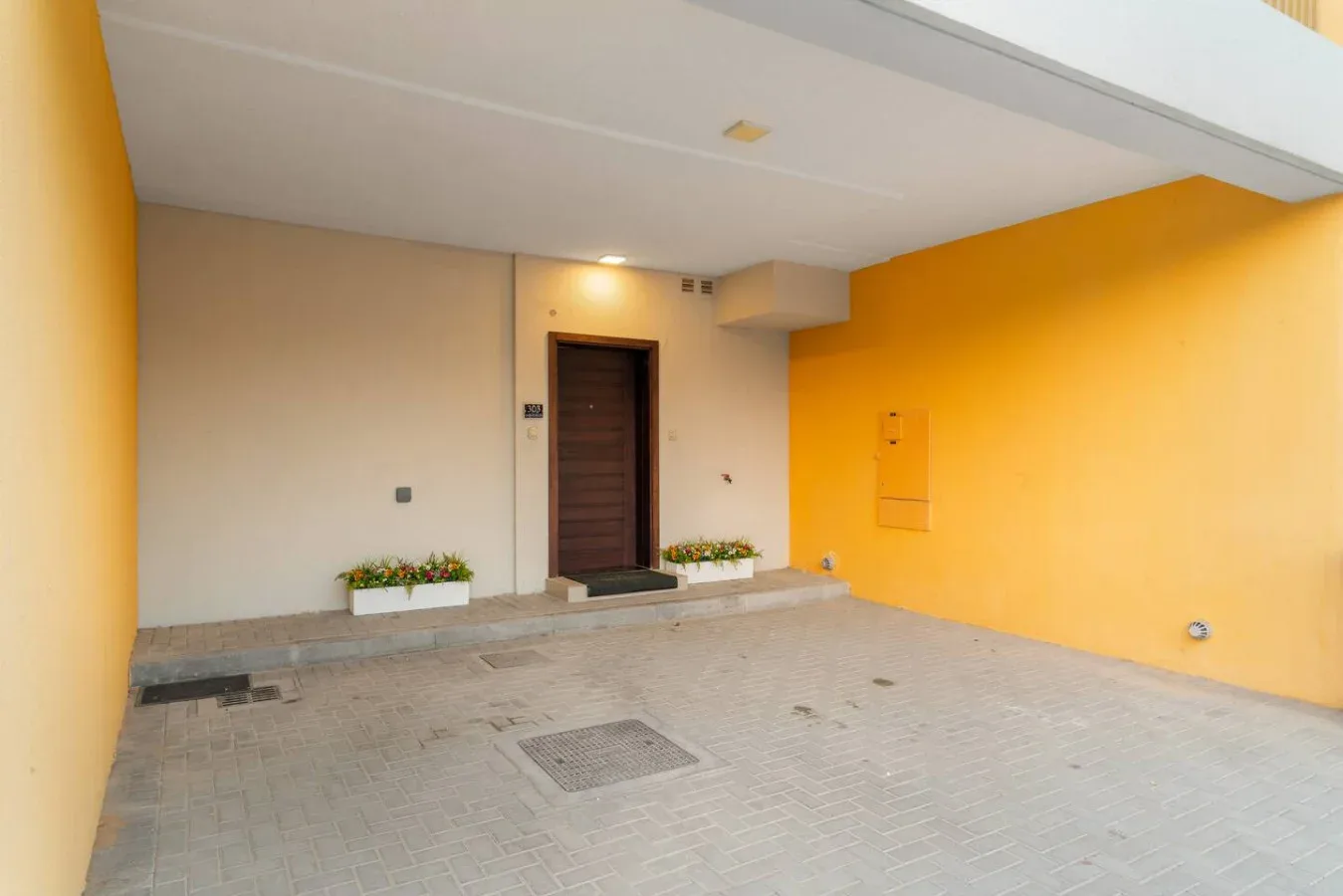 Una entrada cubierta con una puerta oscura y paredes de color naranja brillante.
