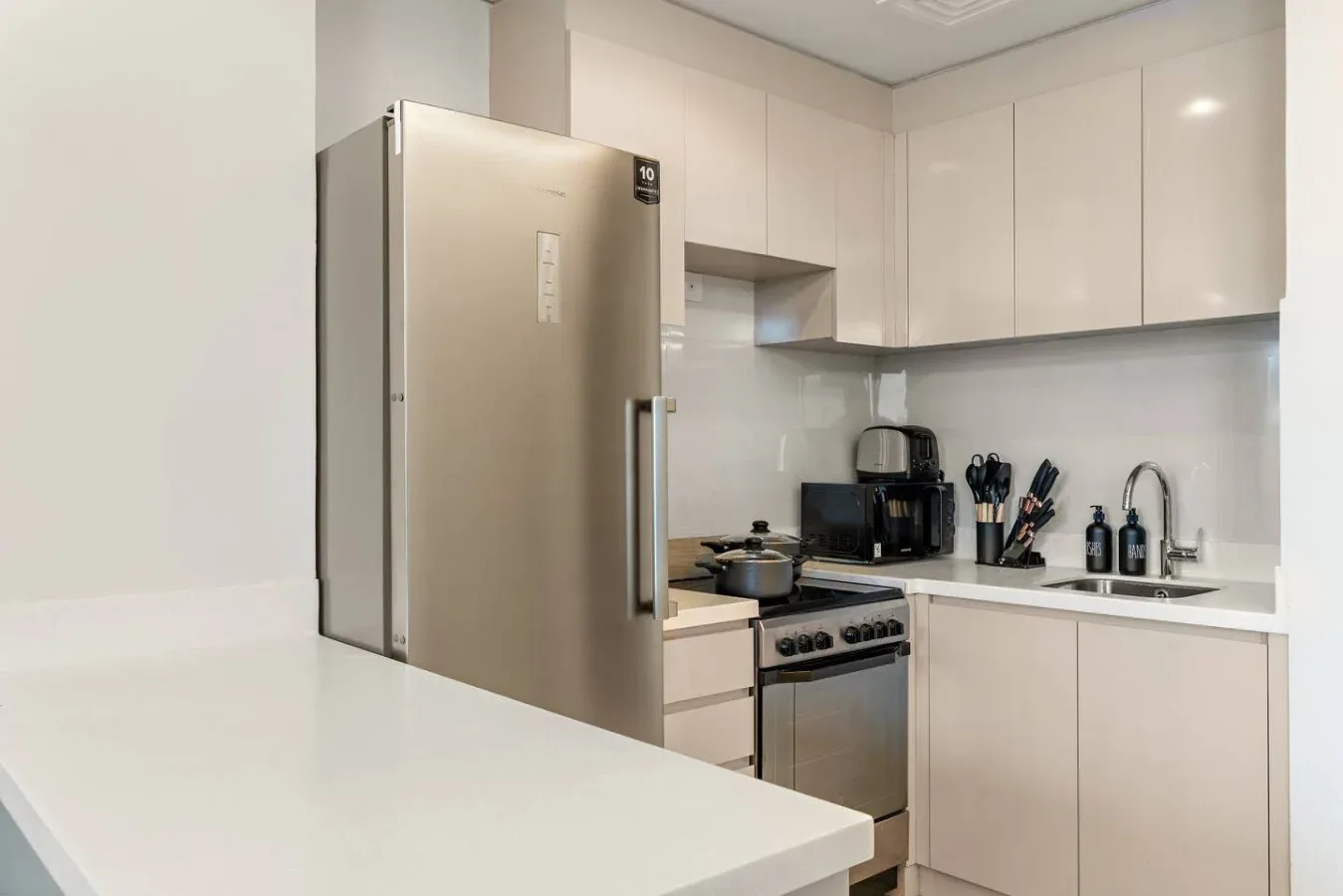 Una cocina moderna con refrigerador, estufa y encimera.