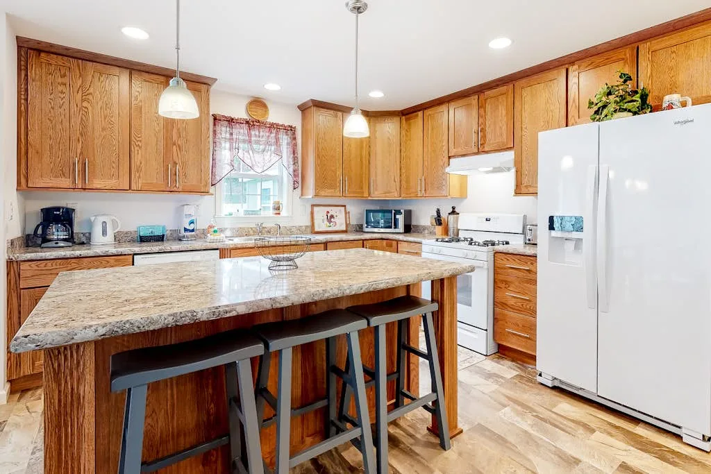 A kitchen with wooden cabinets and a large island with seating.