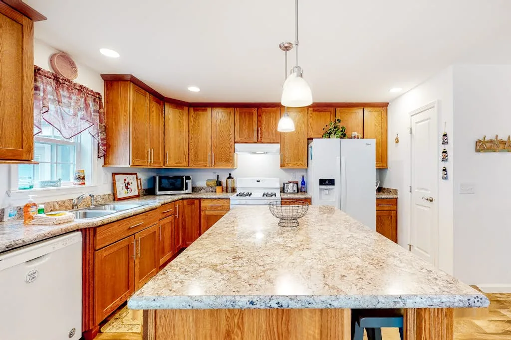 A bright kitchen with wooden cabinets and a large central island.