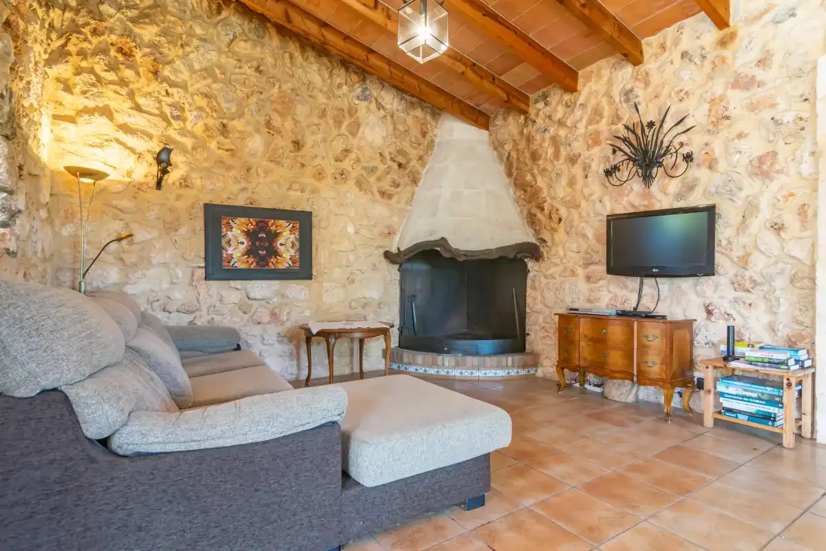 Una sala de estar rústica con asientos, una chimenea y un televisor.