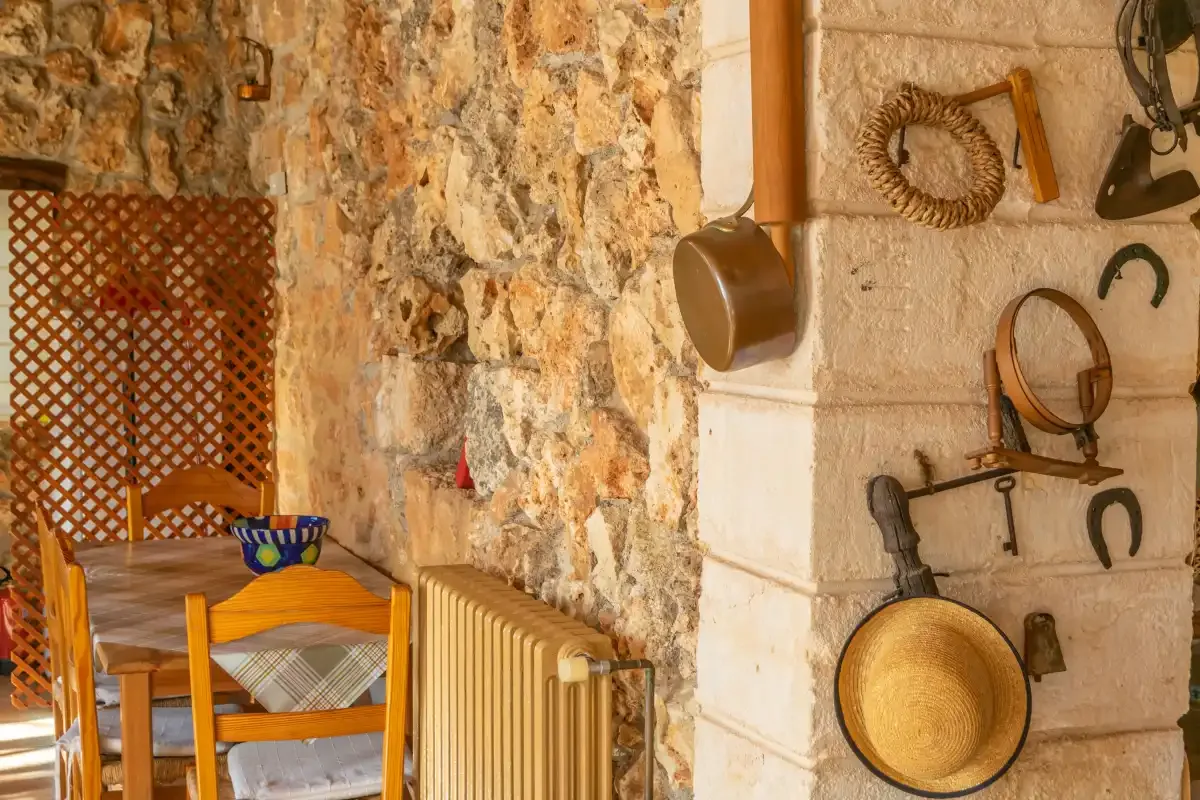 Una zona de comedor rústica con una mesa de madera junto a paredes de piedra vista.