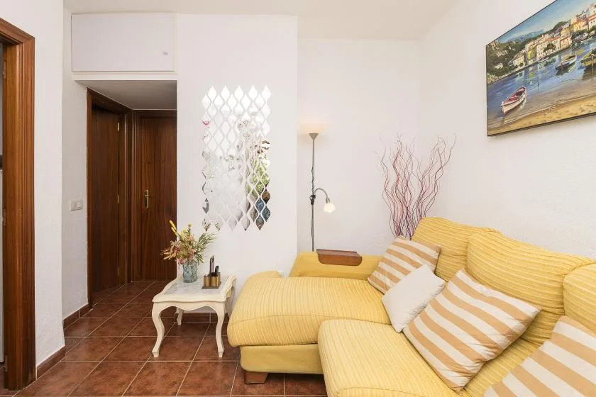 A living room with yellow seating and a small white side table.