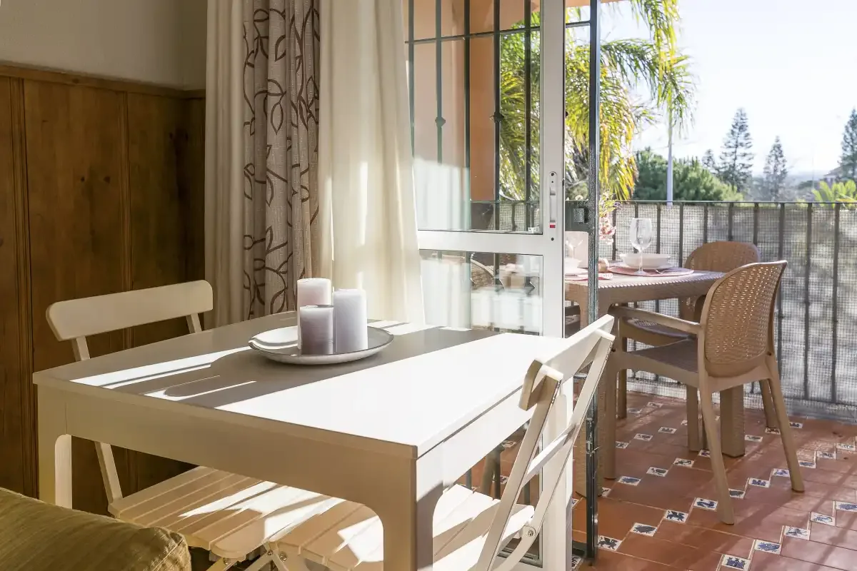 A dining area with a table and chairs beside an open patio.