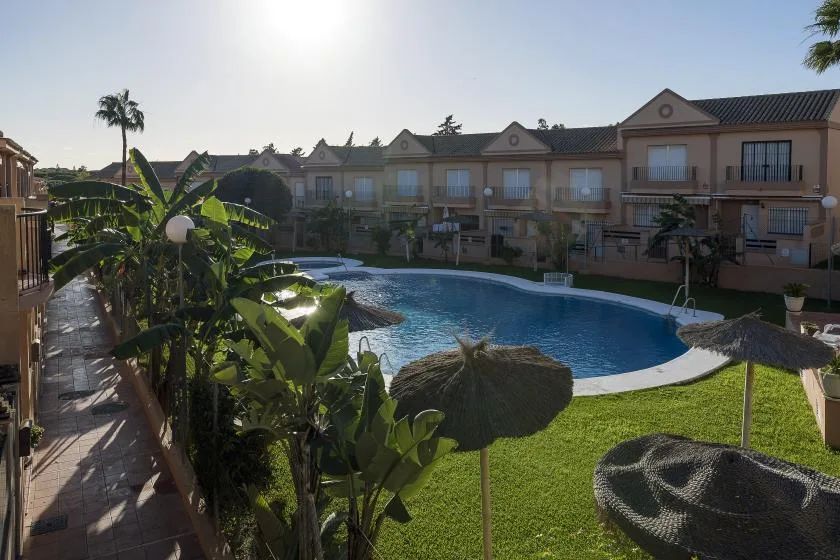 A swimming pool sits in a landscaped courtyard surrounded by multi-story buildings.