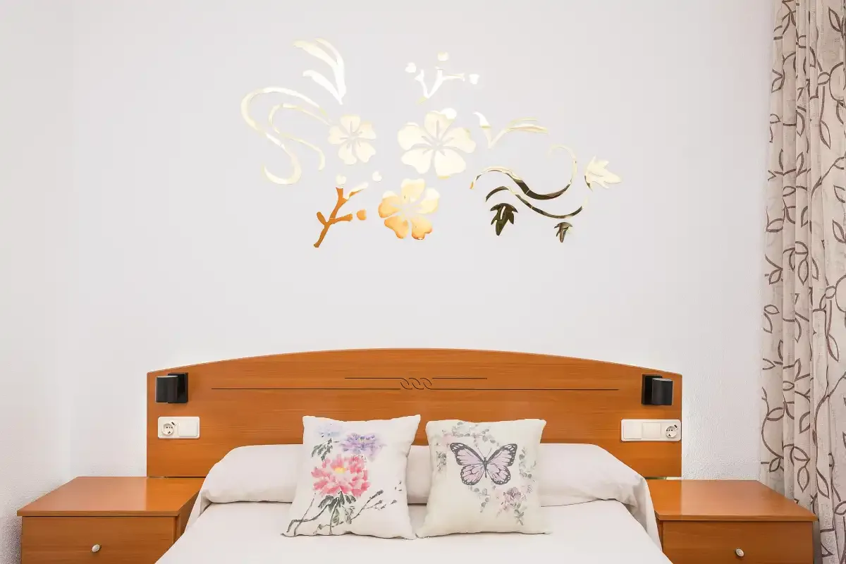 A bedroom with a wooden headboard and floral wall decoration.