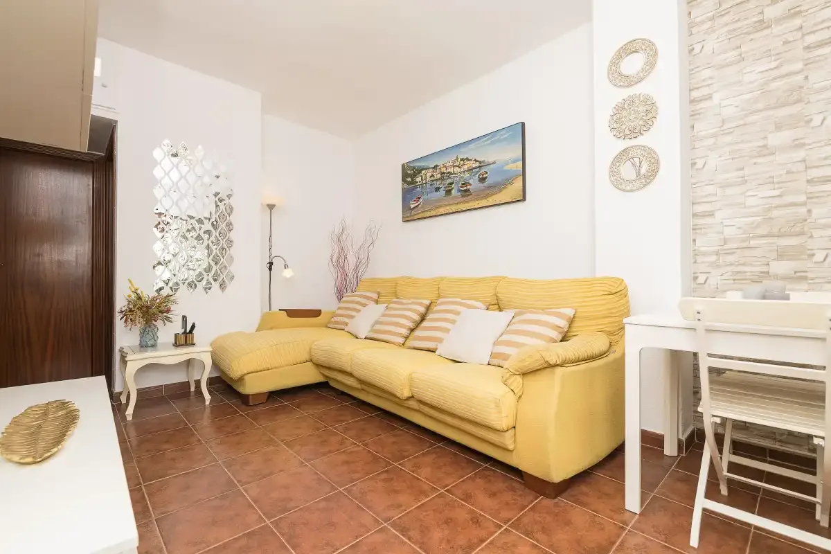 A living room with yellow seating and a small dining table.