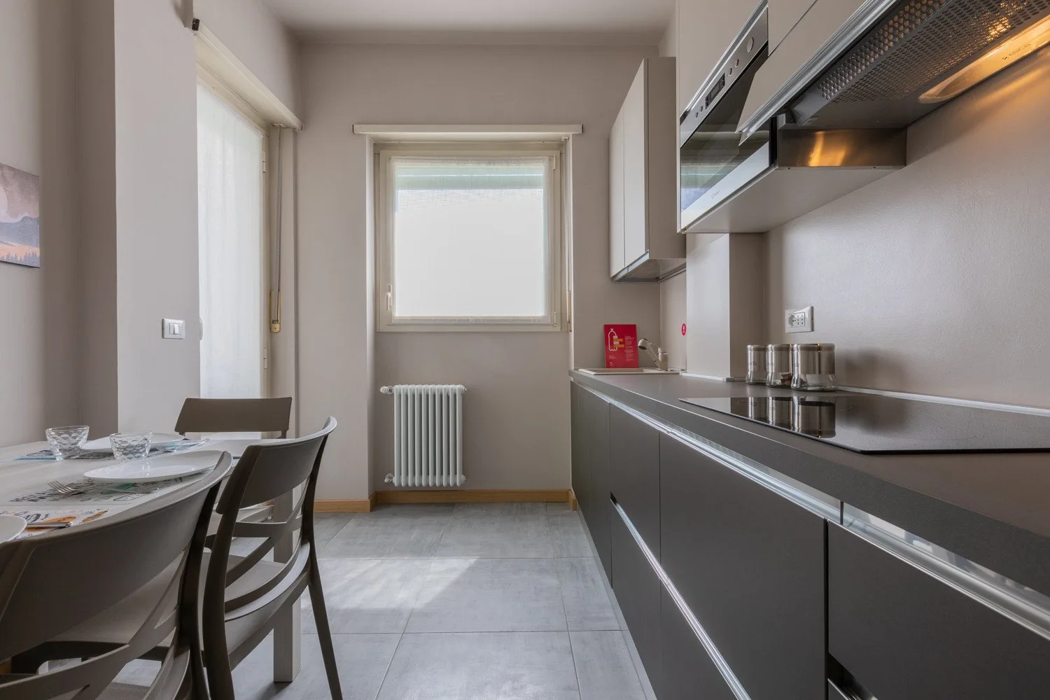 A compact kitchen with a dining table beside the counter and window.