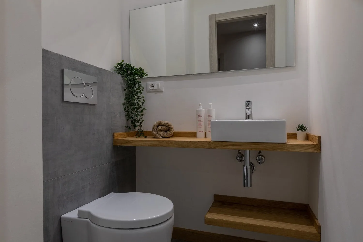 A bathroom vanity with a vessel sink, wooden counter, and mirror above.