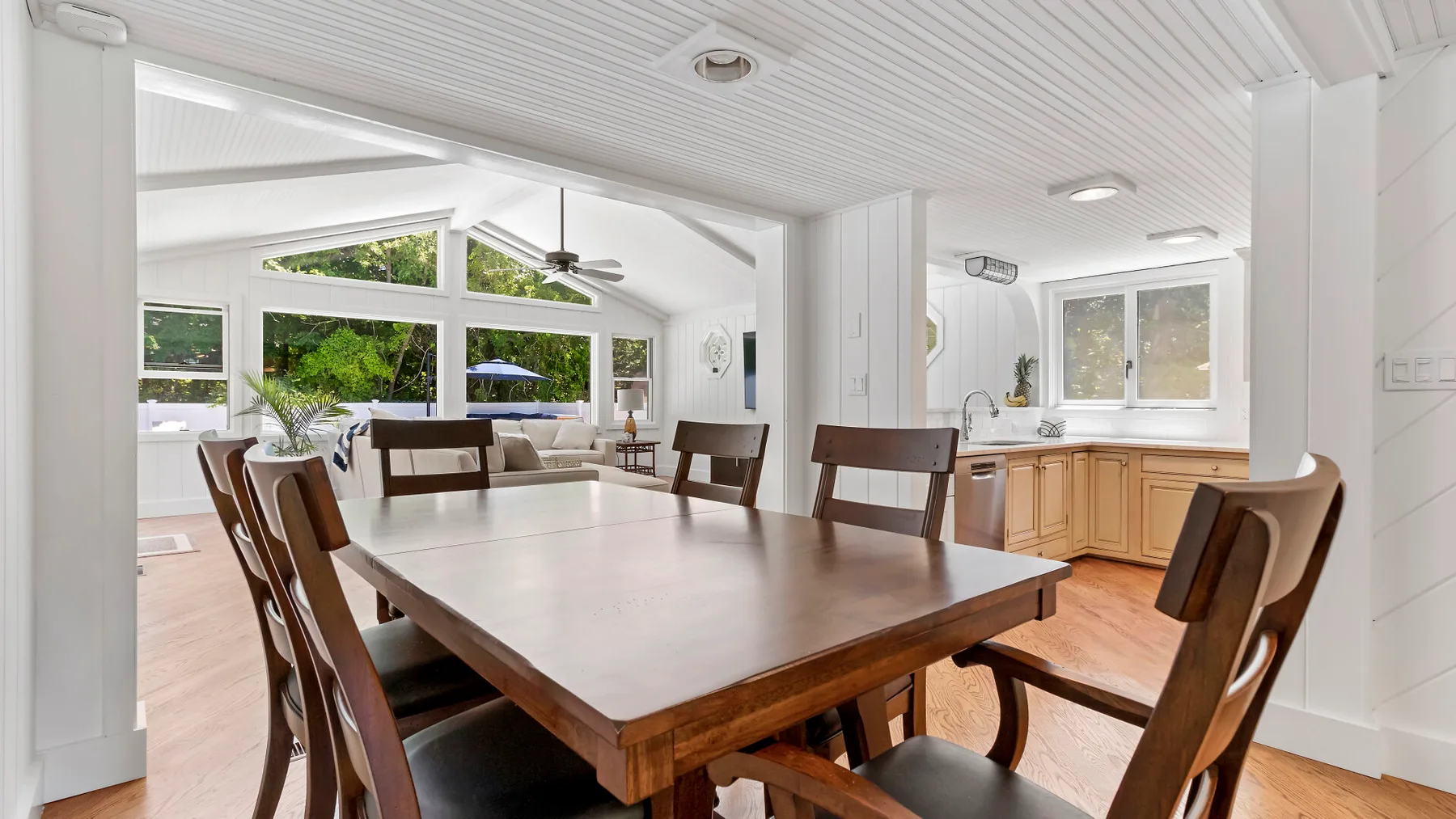 Un comedor luminoso con una mesa de madera y vistas a la cocina.
