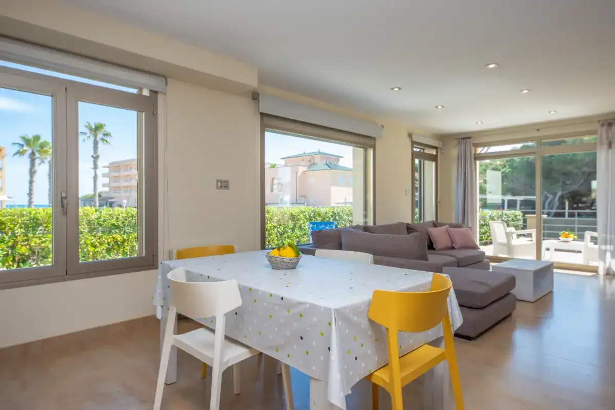 A bright living and dining area with a table beside the seating area.