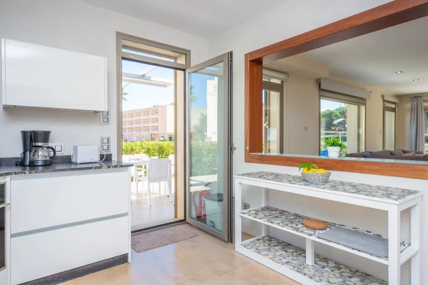 A bright kitchen opens onto a balcony, with a serving counter beside the doorway.